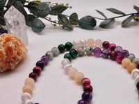 closeup of 8mm gemstone beads in Amethyst, Green Tiger's Eye, Tibetan Agate, Pink Aventurine and Kiwi Jasper